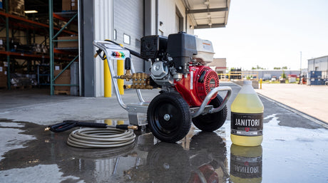 Commercial gas pressure washer on a clean concrete loading dock beside a JANITORI Degreaser MAX No.72 jug