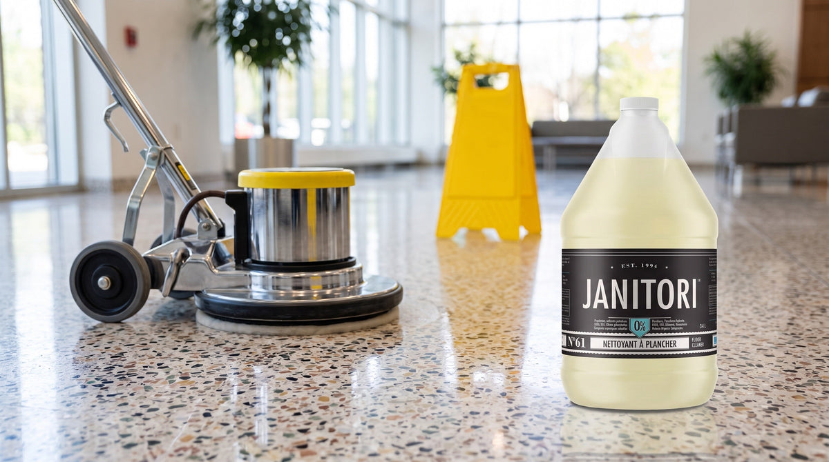 Floor scrubber cleaning a terrazzo lobby floor beside a JANITORI Floor Cleaner No.61 jug