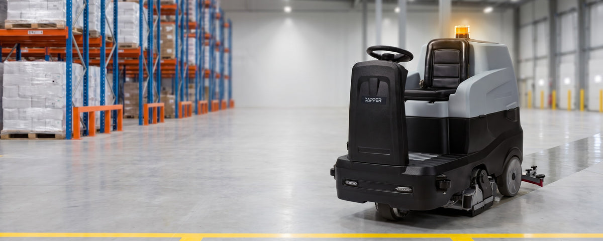Dapper ride-on floor scrubber in a warehouse aisle